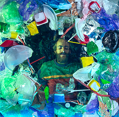 Image showing Man drowning in ocean water under plastic recipients pile, environment concept