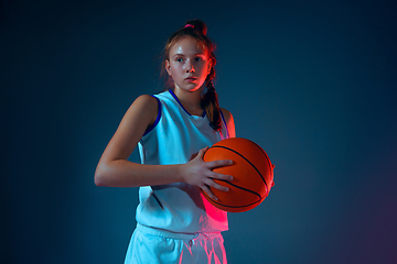 Image showing Young caucasian female basketball player on blue studio background in neon light