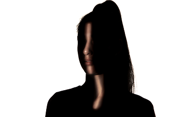 Image showing Dramatic portrait of a girl in the dark on white studio background.