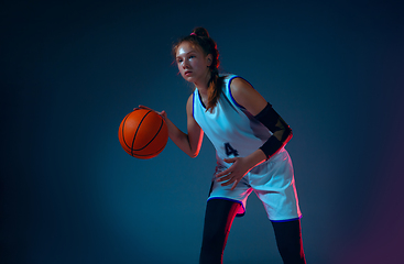 Image showing Young caucasian female basketball player on blue studio background in neon light