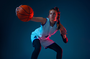 Image showing Young caucasian female basketball player on blue studio background in neon light