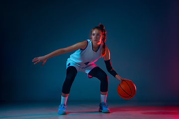 Image showing Young caucasian female basketball player on blue studio background in neon light