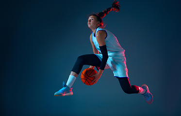 Image showing Young caucasian female basketball player on blue studio background in neon light