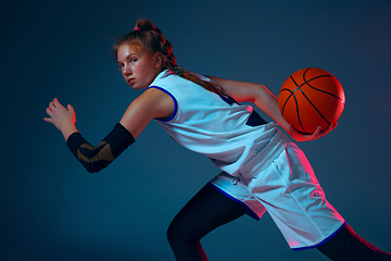 Image showing Young caucasian female basketball player on blue studio background in neon light