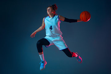 Image showing Young caucasian female basketball player on blue studio background in neon light