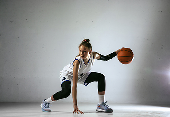 Image showing Young caucasian female basketball player against white wall background