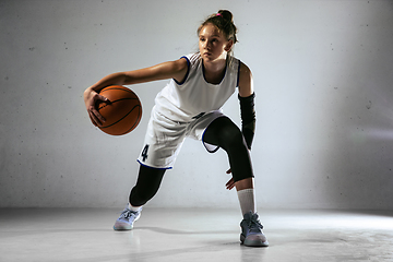 Image showing Young caucasian female basketball player against white wall background