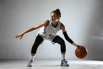 Image showing Young caucasian female basketball player against white wall background