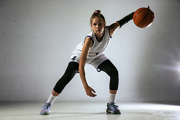 Image showing Young caucasian female basketball player against white wall background