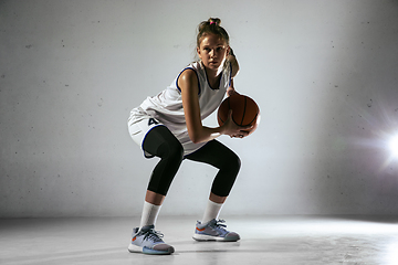 Image showing Young caucasian female basketball player against white wall background
