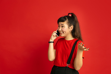 Image showing Asian teenager\'s portrait isolated on red studio background