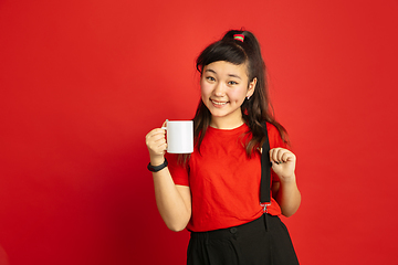 Image showing Asian teenager\'s portrait isolated on red studio background