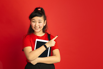 Image showing Asian teenager\'s portrait isolated on red studio background