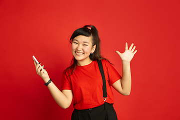 Image showing Asian teenager\'s portrait isolated on red studio background