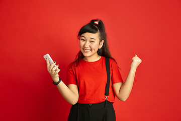 Image showing Asian teenager\'s portrait isolated on red studio background