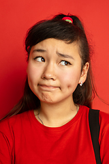 Image showing Asian teenager\'s close up portrait isolated on red studio background