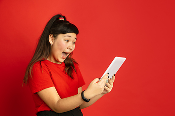 Image showing Asian teenager\'s portrait isolated on red studio background