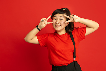 Image showing Asian teenager\'s portrait isolated on red studio background