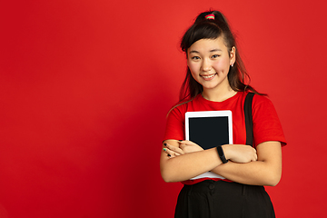 Image showing Asian teenager\'s portrait isolated on red studio background