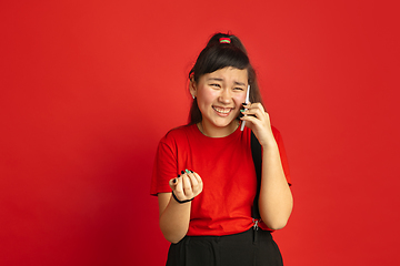 Image showing Asian teenager\'s portrait isolated on red studio background