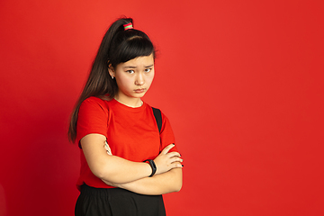 Image showing Asian teenager\'s portrait isolated on red studio background