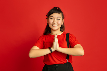Image showing Asian teenager\'s portrait isolated on red studio background