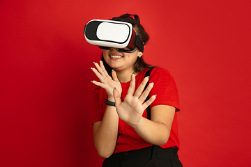 Image showing Asian teenager\'s portrait isolated on red studio background