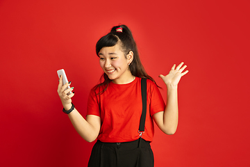 Image showing Asian teenager\'s portrait isolated on red studio background