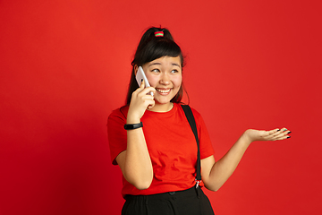 Image showing Asian teenager\'s portrait isolated on red studio background