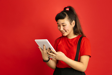 Image showing Asian teenager\'s portrait isolated on red studio background