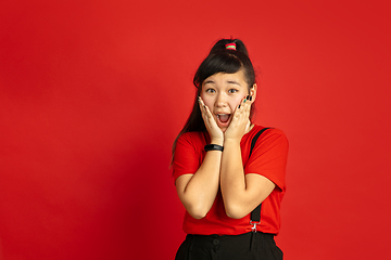 Image showing Asian teenager\'s portrait isolated on red studio background