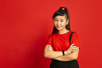 Image showing Asian teenager\'s portrait isolated on red studio background