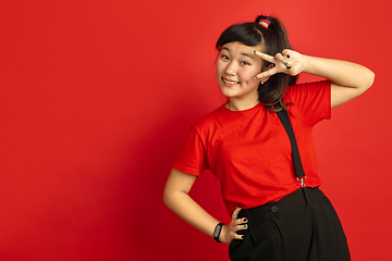 Image showing Asian teenager\'s portrait isolated on red studio background