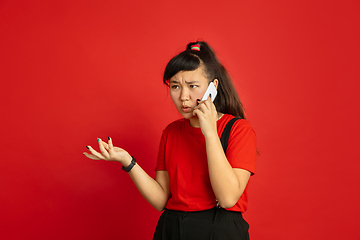 Image showing Asian teenager\'s portrait isolated on red studio background