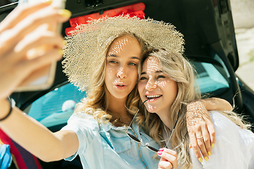 Image showing Young lesbian\'s couple preparing for vacation trip on the car in sunny day