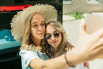 Image showing Young lesbian\'s couple preparing for vacation trip on the car in sunny day