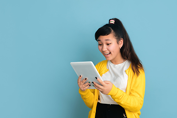 Image showing Asian teenager\'s portrait isolated on blue studio background