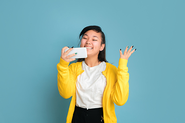 Image showing Asian teenager\'s portrait isolated on blue studio background