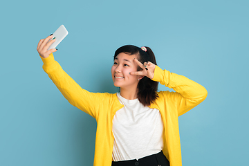 Image showing Asian teenager\'s portrait isolated on blue studio background