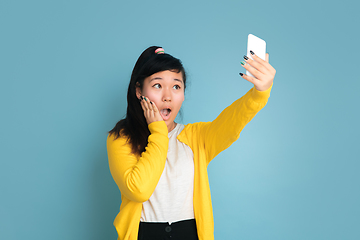 Image showing Asian teenager\'s portrait isolated on blue studio background