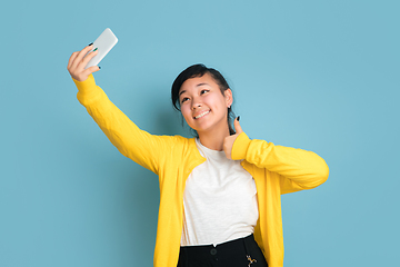 Image showing Asian teenager\'s portrait isolated on blue studio background