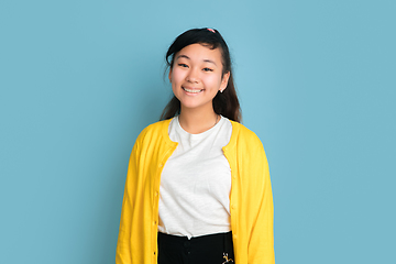 Image showing Asian teenager\'s portrait isolated on blue studio background