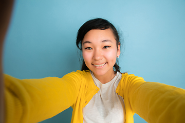 Image showing Asian teenager\'s portrait isolated on blue studio background