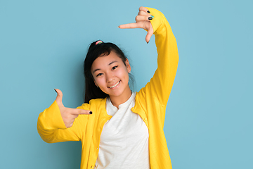 Image showing Asian teenager\'s portrait isolated on blue studio background