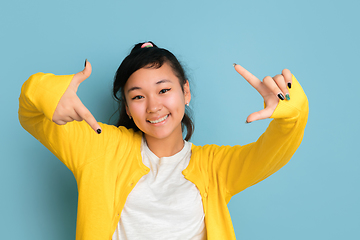 Image showing Asian teenager\'s portrait isolated on blue studio background