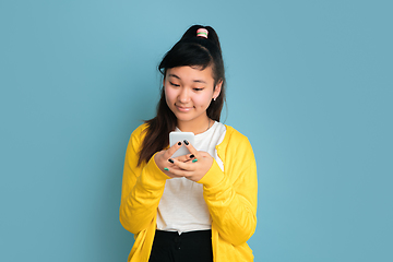 Image showing Asian teenager\'s portrait isolated on blue studio background