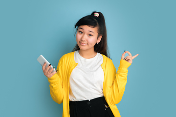 Image showing Asian teenager\'s portrait isolated on blue studio background