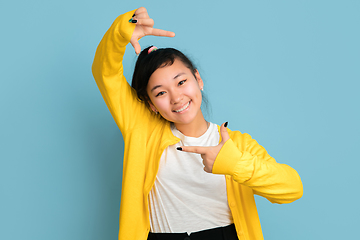 Image showing Asian teenager\'s portrait isolated on blue studio background