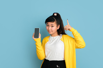 Image showing Asian teenager\'s portrait isolated on blue studio background