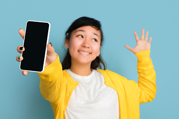 Image showing Asian teenager\'s portrait isolated on blue studio background